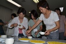 北海道の冷凍コーンの工場にて、北海道産と米国産を食べ比べている様子